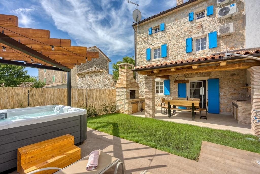 a backyard with a hot tub and a building at Casa Darel with Whirlpool in Vižinada