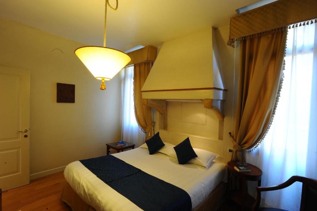 a bedroom with a bed with a lamp and a window at Locanda del Ghetto in Venice