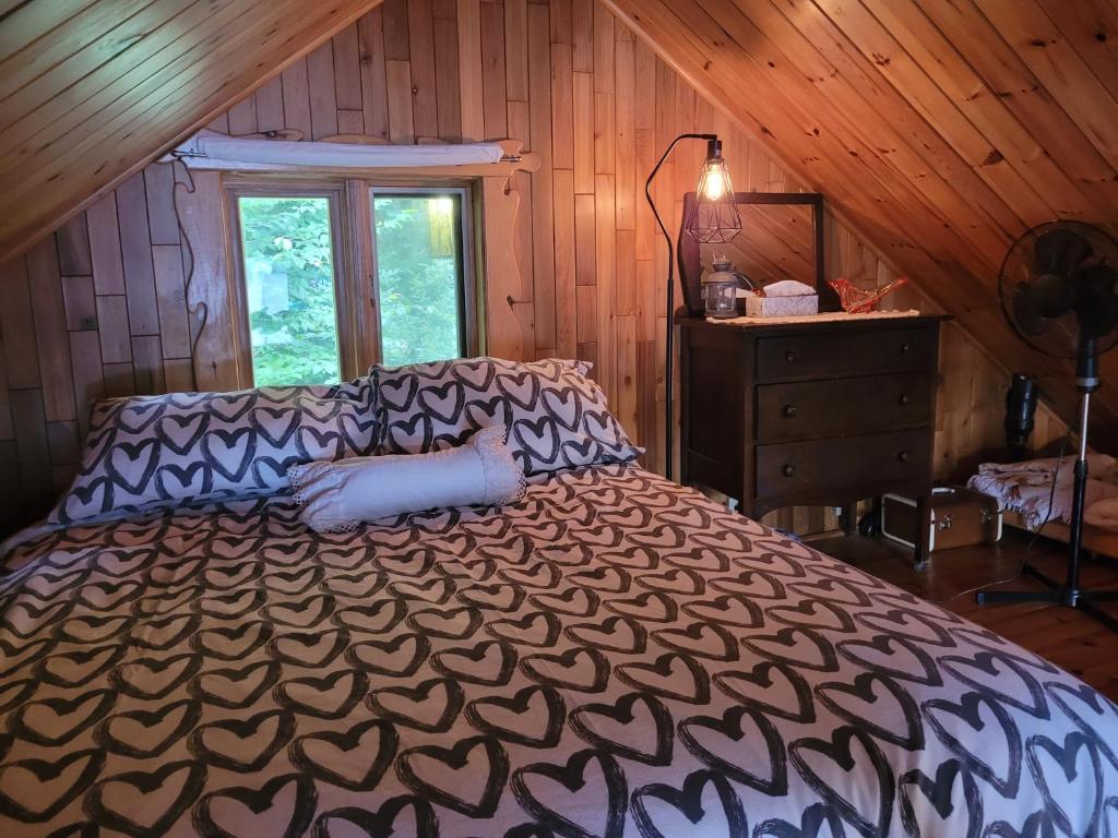 - une chambre avec un lit dans une pièce en bois dans l'établissement Le petit chalet sur le lac, à Sainte-Marguerite