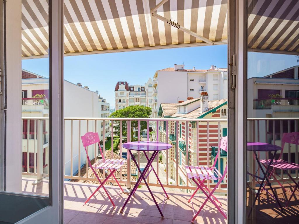 d'un balcon avec des chaises violettes et une vue sur la ville. dans l'établissement Apartment Chubero by Interhome, à Sainte-Barbe