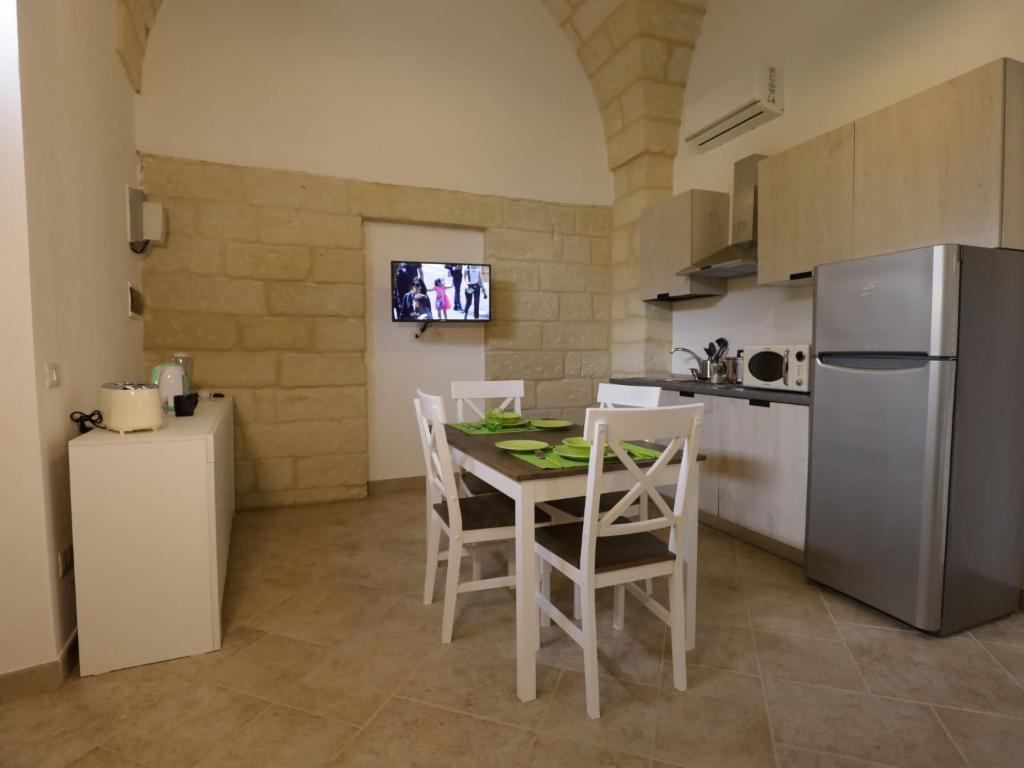 cocina con mesa, sillas y nevera en Apartment Spicchi di Salento-3 by Interhome, en Vernole