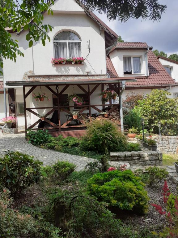 a house with a porch and flowers in front of it at Willa Parkowa in Szklarska Poręba