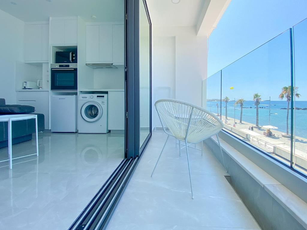 uma sala de estar com uma cadeira e vista para o oceano em Phaedrus Living: Marina Sea View Flat 214 Gold em Pafos