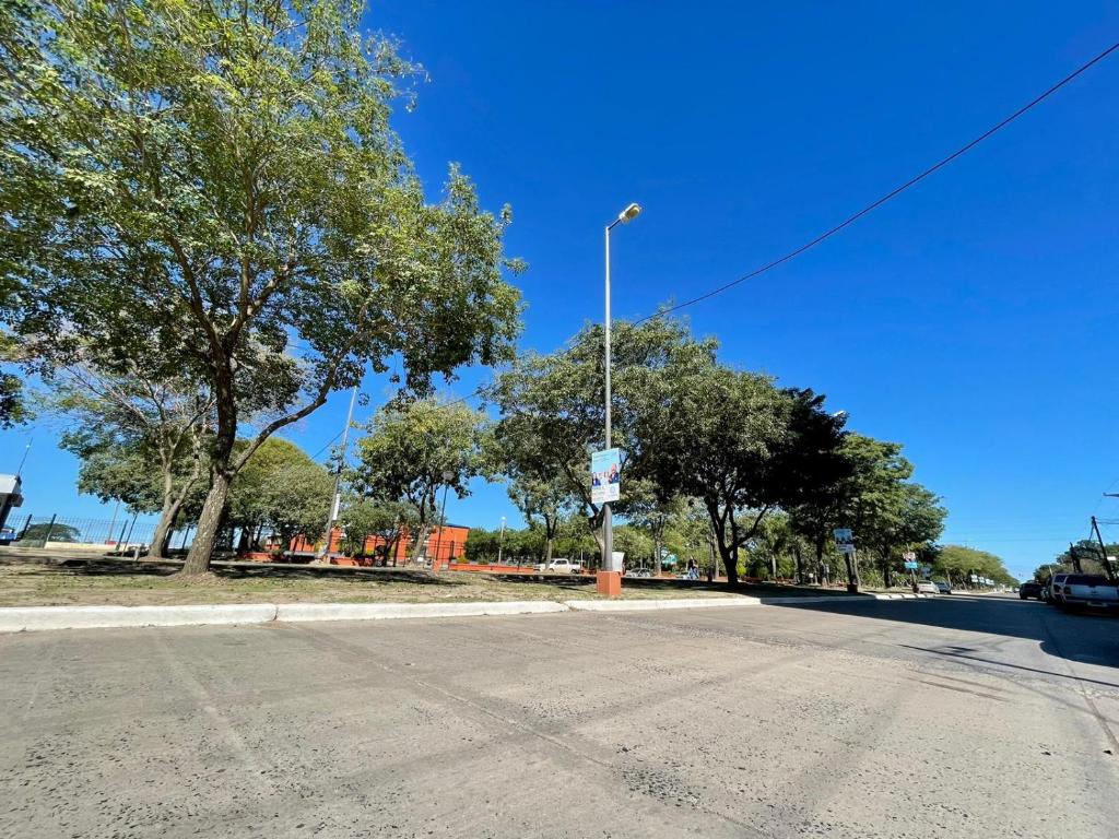 an empty street with a street light and trees at La Francisca II in Formosa