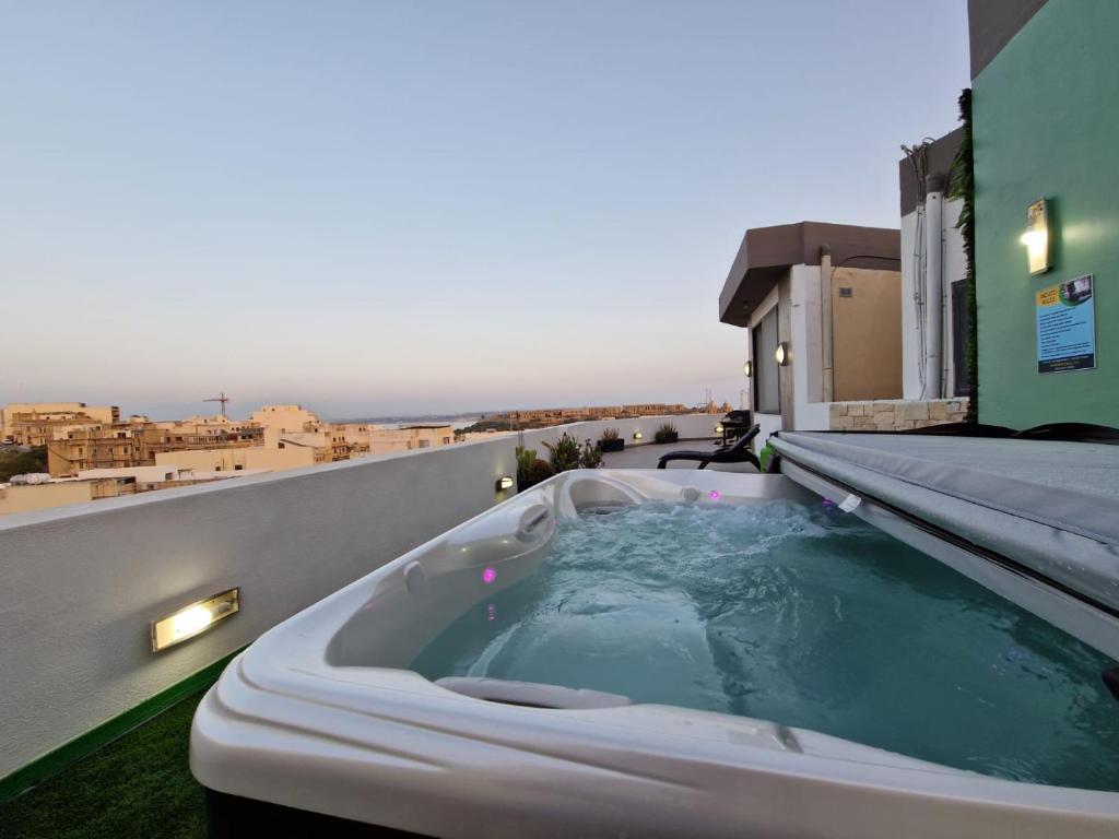 a bath tub on the roof of a building at Millennium Penthouse with private Hot Tub Gozo in Għajnsielem