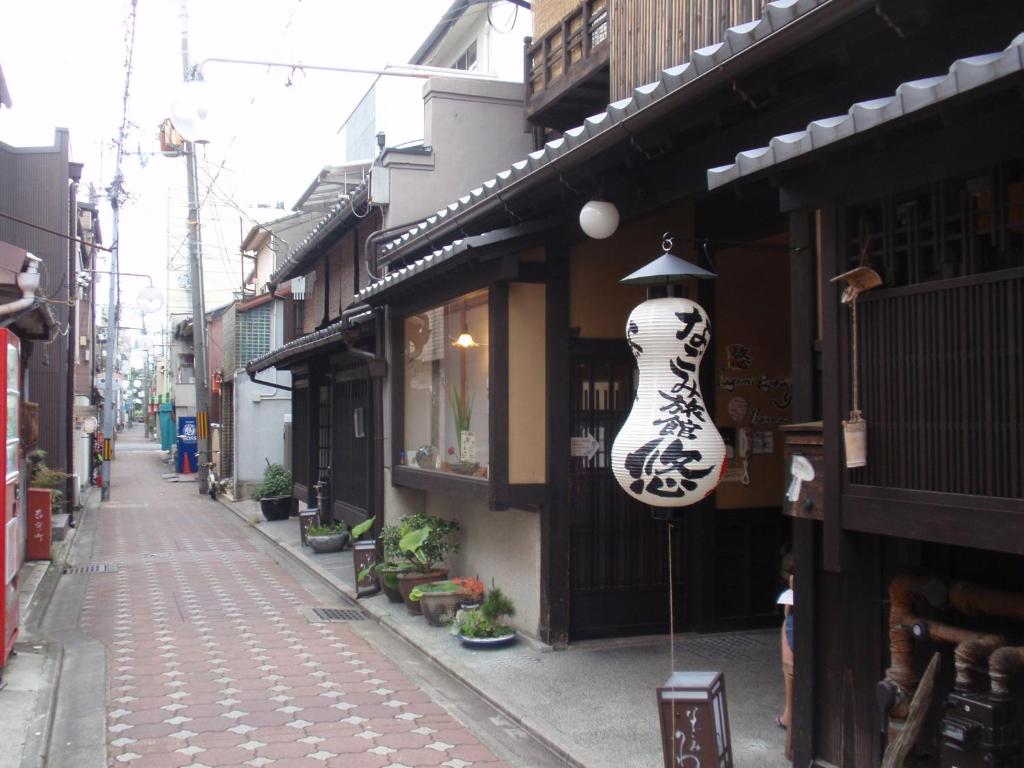 una calle con un jarrón colgando del lado de un edificio en Nagomi-Ryokan Yuu, en Kioto