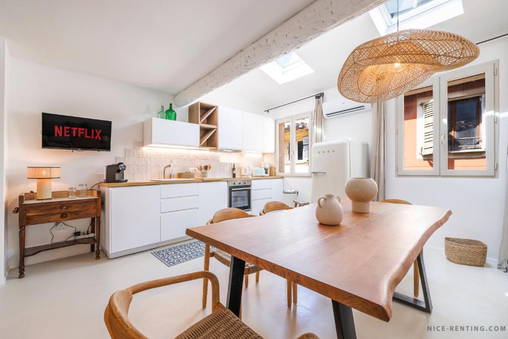 une cuisine et une salle à manger avec une table et des chaises en bois dans l'établissement Nice Renting - NEUVE - Luxury Triplex Old Town Massena Garibaldi - 4 BedRoom - AC, à Nice