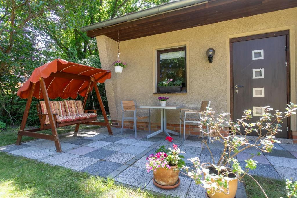 a patio with a table and a chair and a house at Ferienhaus Krohse in Potsdam