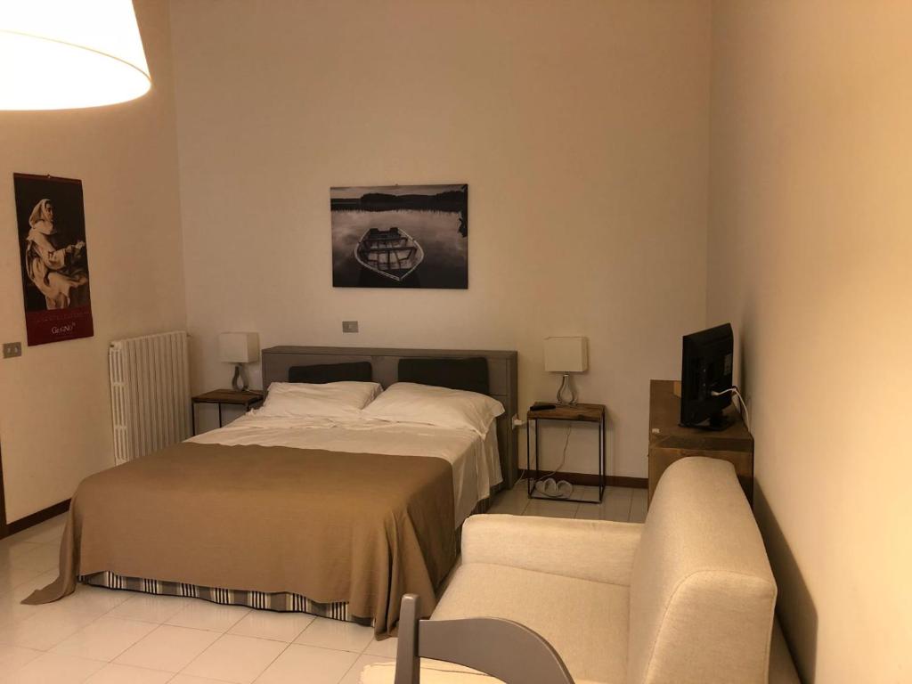 クレモナにあるCremona Appartamento Monolocale Sant'Omobonoのベッドルーム(ベッド1台、ソファ付)