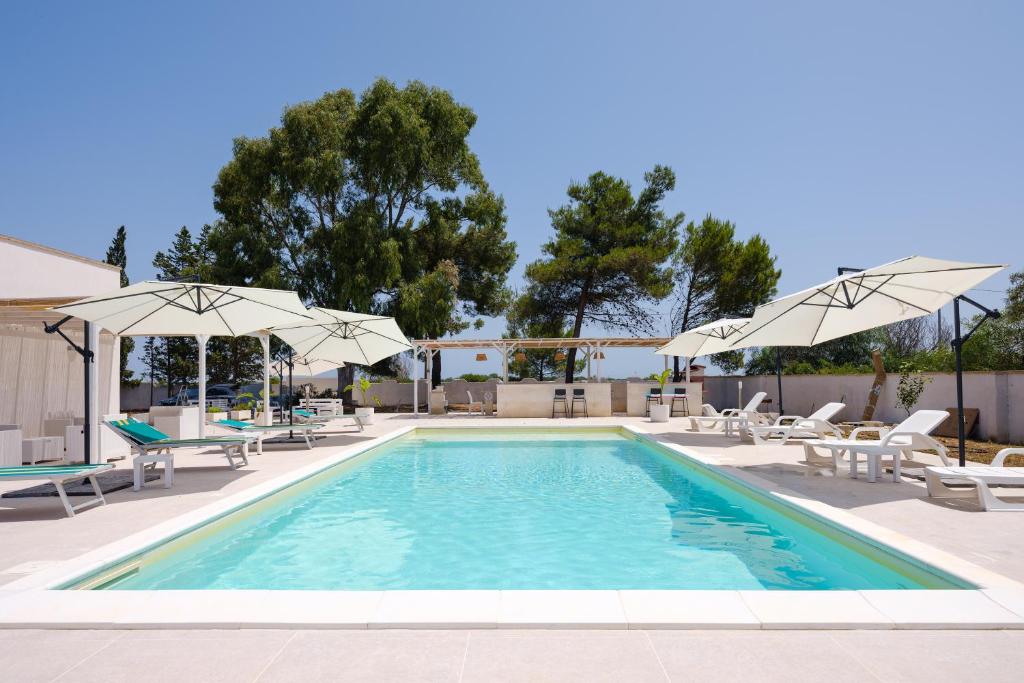 - une piscine avec des chaises longues et des parasols dans l'établissement Villa Chiara, à Lecce