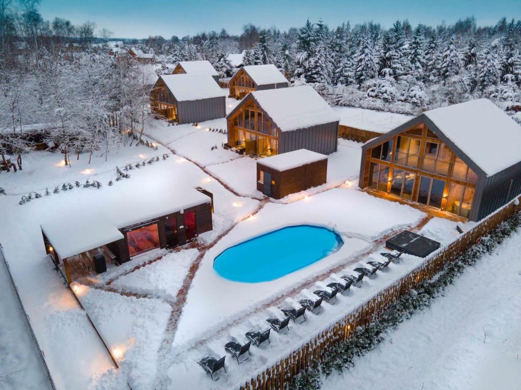 KrasneにあるKrasne Residence & SPA - STREFA CISZYのスイミングプール付きの雪の中のリゾート