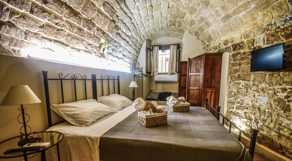 um quarto com uma cama numa parede de pedra em Domum in petra casa nella roccia Self check - in em Modica