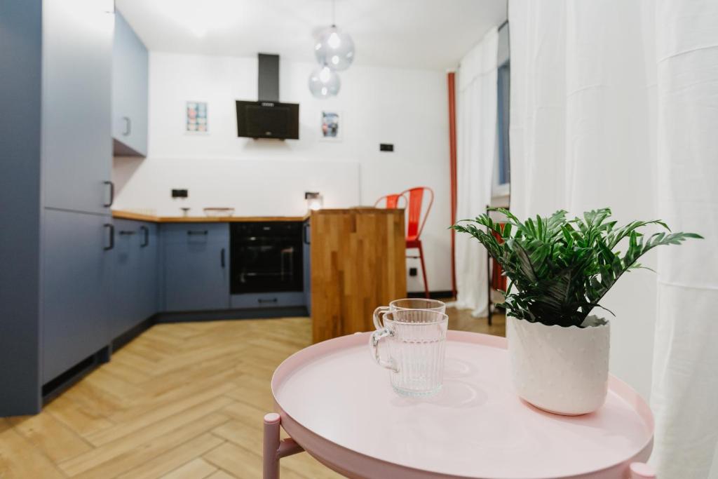 a white table with a plant on it in a kitchen at Apartament Lwowska in Lublin