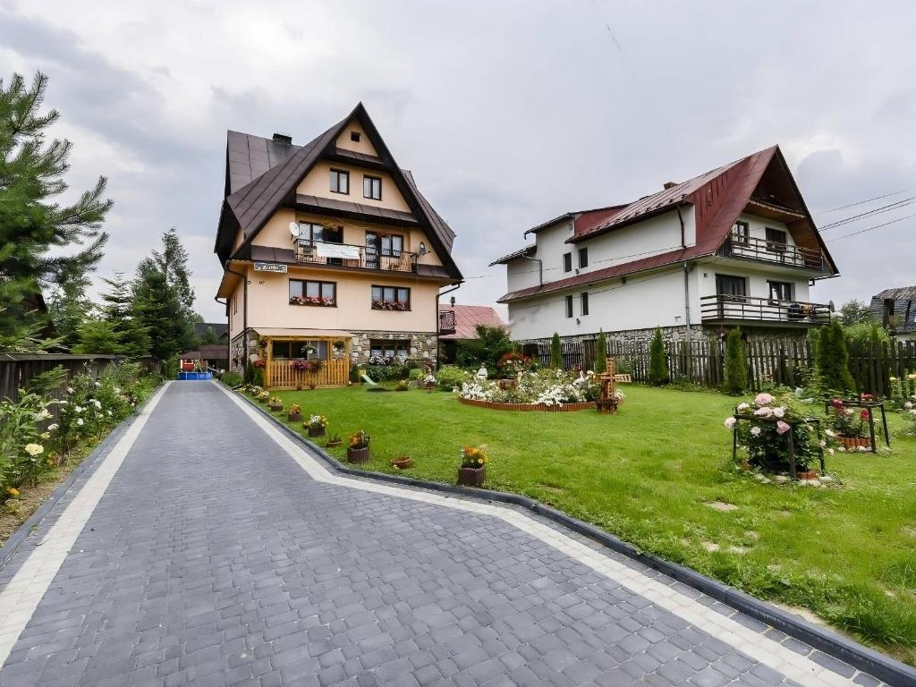 une route pavée devant deux maisons dans l'établissement U Ziutka, à Jurgów