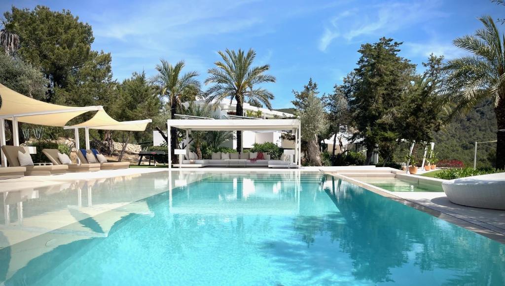 una piscina con una villa sullo sfondo di Casa Tyane a Sant Jordi