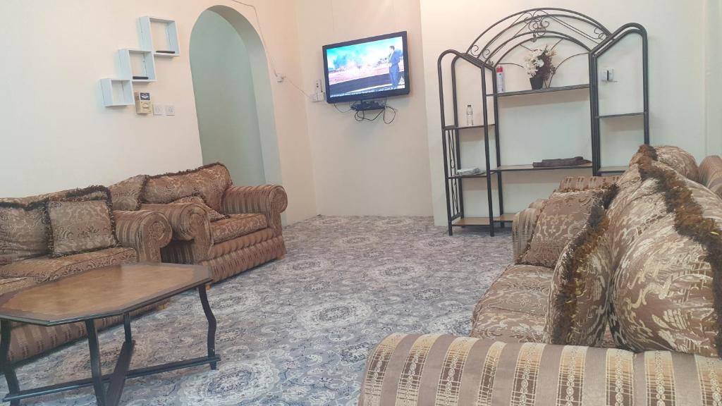 a living room with two couches and a tv at Madinah Anbariah in Al Madinah