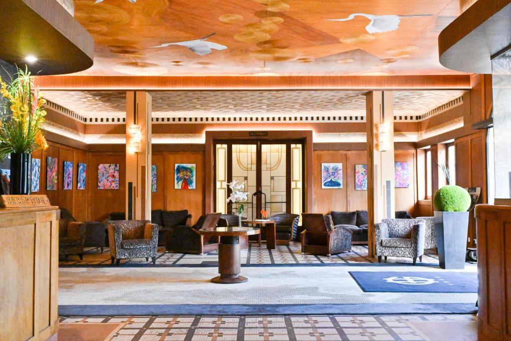 a lobby with chairs and a table in a building at Le Grand Hotel in Tours
