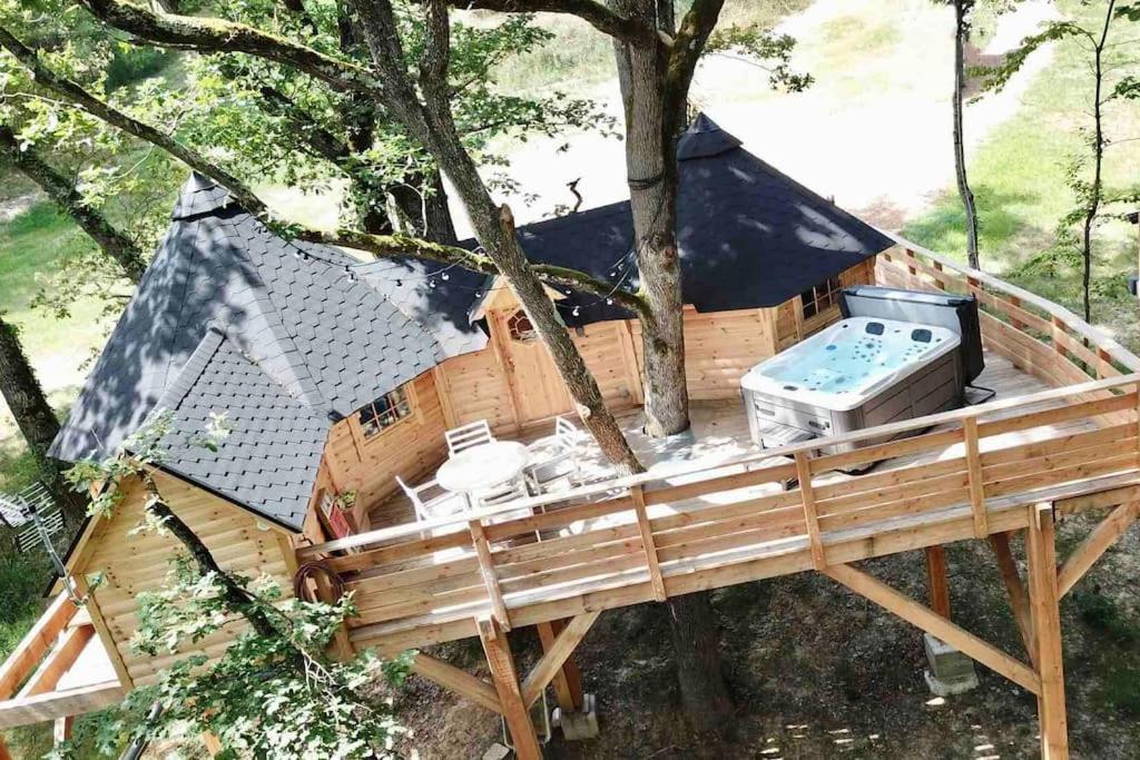 ein Baumhaus mit einer Badewanne in einem Baum in der Unterkunft La Cabane perchée de la Mure in Bongheat