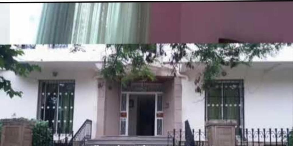 a large white house with a porch and a door at Quartier riad résidence riad in Ifrane