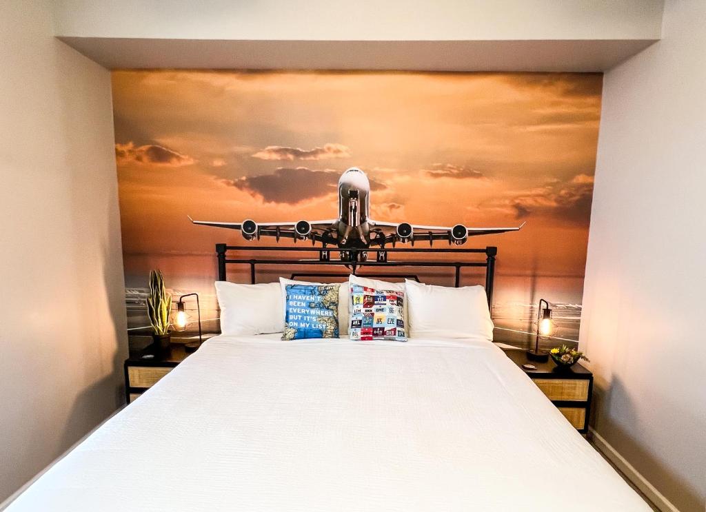 a bedroom with a large bed with an airplane on the wall at The Aviator's Club - Central Downtown Sandusky in Sandusky