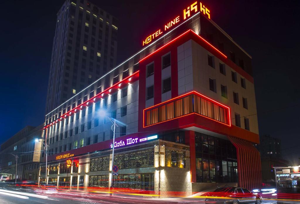 a building with a neon sign on the side of it at Hotel Nine Ulaanbaatar in Ulaanbaatar