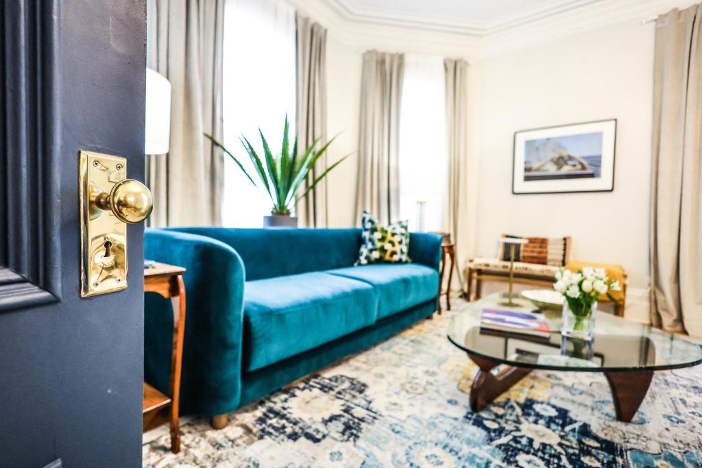 盧嫩堡的住宿－The Lunenburg Inn，客厅配有蓝色的沙发和桌子