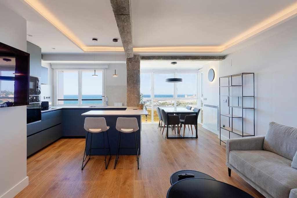a kitchen and living room with a couch and a table at Argus San Lorenzo By Silastur in Gijón