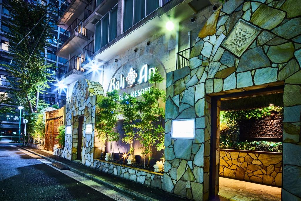 a building with a sign on the side of it at night at Hotel BaliAn Resort Yokohama Kannai - Adult Only in Yokohama