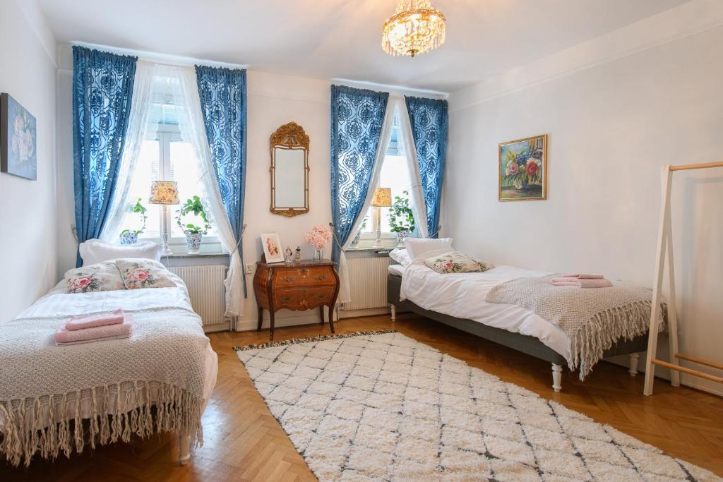 a bedroom with two beds and two windows at HoMade B&B, Gamla Stan in Norrköping