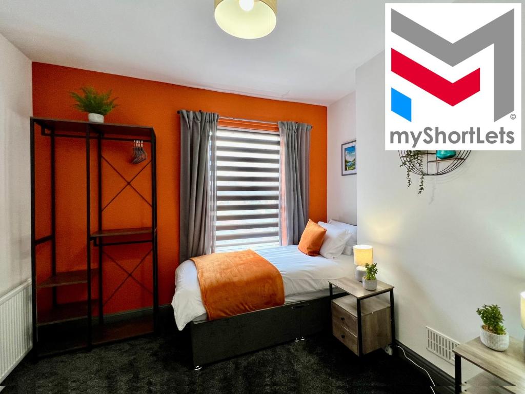 1 dormitorio con paredes de color naranja, 1 cama y ventana en Birkin House - Great for Contractors or Family Holidays en Nottingham