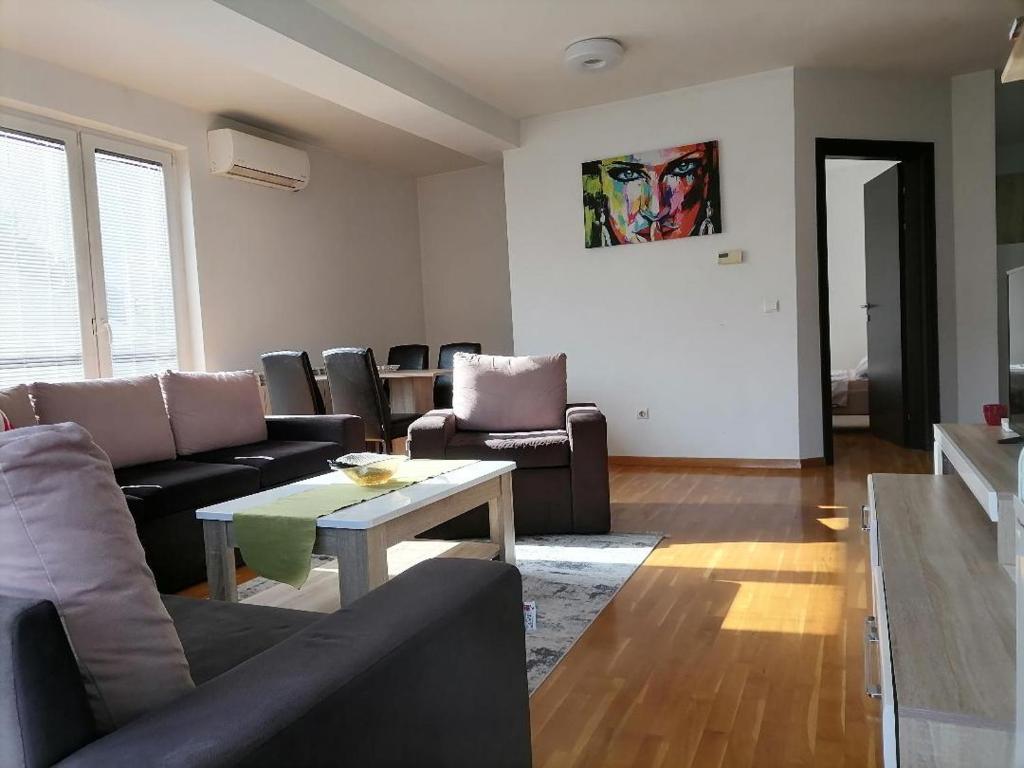 a living room with a couch and a table at Big Apartment with private parking - EXTRA VIEW in Skopje