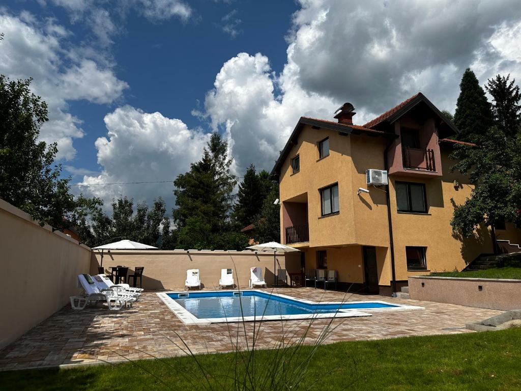 a house and a swimming pool in front of a house at Villa Mercurii in Sarajevo