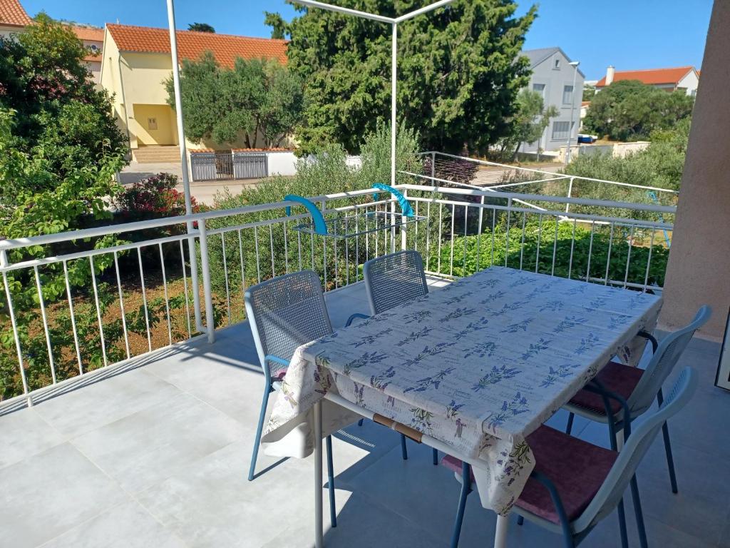 una mesa azul y sillas en el balcón en Apartmani Rameša, en Murter