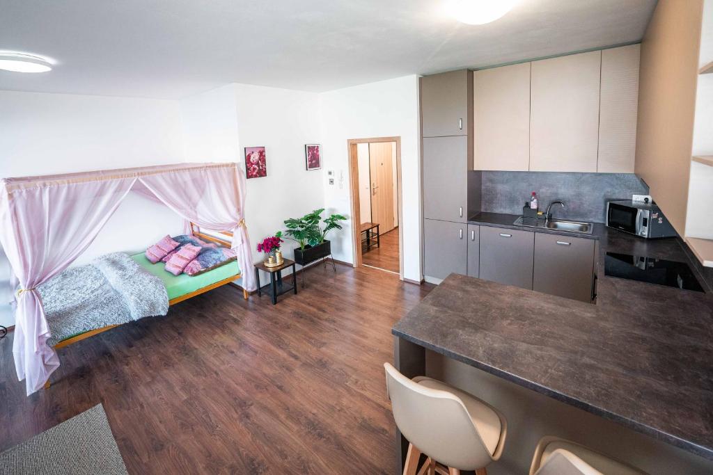 uma sala de estar com uma cama e uma cozinha em GLAM apartmán Bučovice em Bučovice