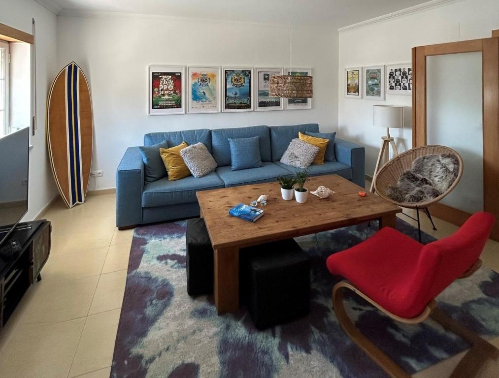 een woonkamer met een blauwe bank en een tafel bij Wave - Beach House, Baleal in Baleal