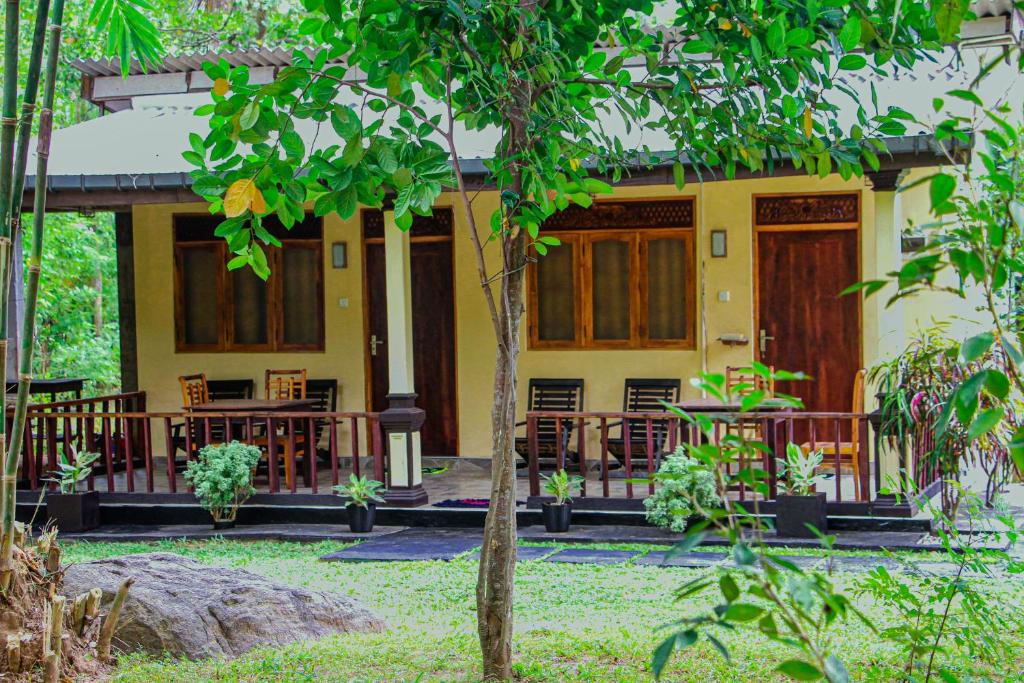 a yellow house with tables and chairs in front of it at Sigiri Nirwana Lodge in Sigiriya
