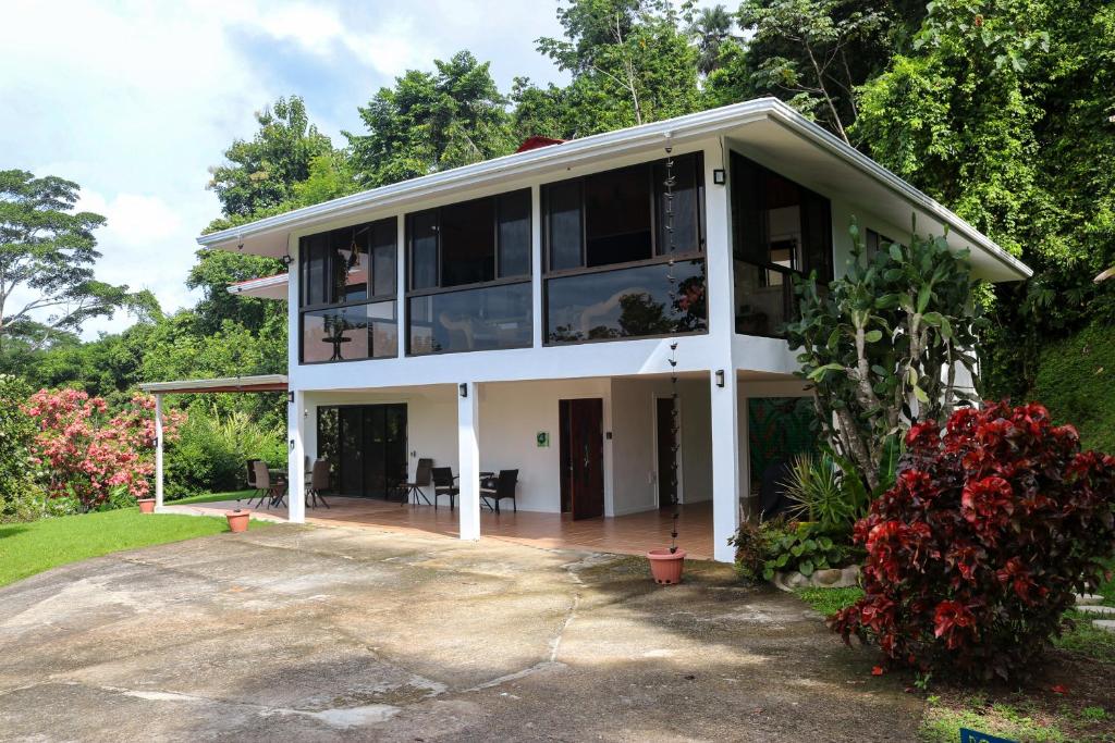ein großes weißes Haus mit vielen Fenstern in der Unterkunft Casa Garrobo in Dominical