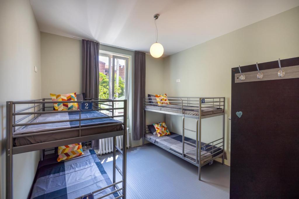 2 stapelbedden in een kamer met een raam bij Bla Bla Hostel in Sofia