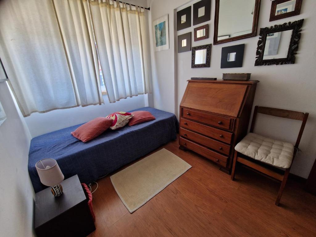 um quarto com uma cama, uma cadeira e uma cómoda em Casa da catarina em Linda-a-Velha