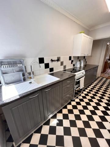 a kitchen with a black and white checkered floor at Antiquated house in Scarborough