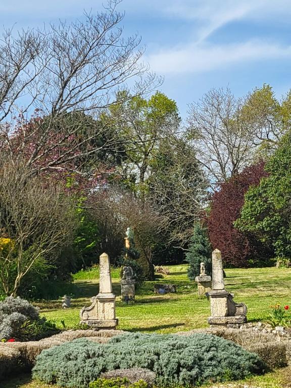 Un cementerio en un parque con flores y árboles en La Closeraie Saint Girons en Saint-Girons-dʼAiguevives