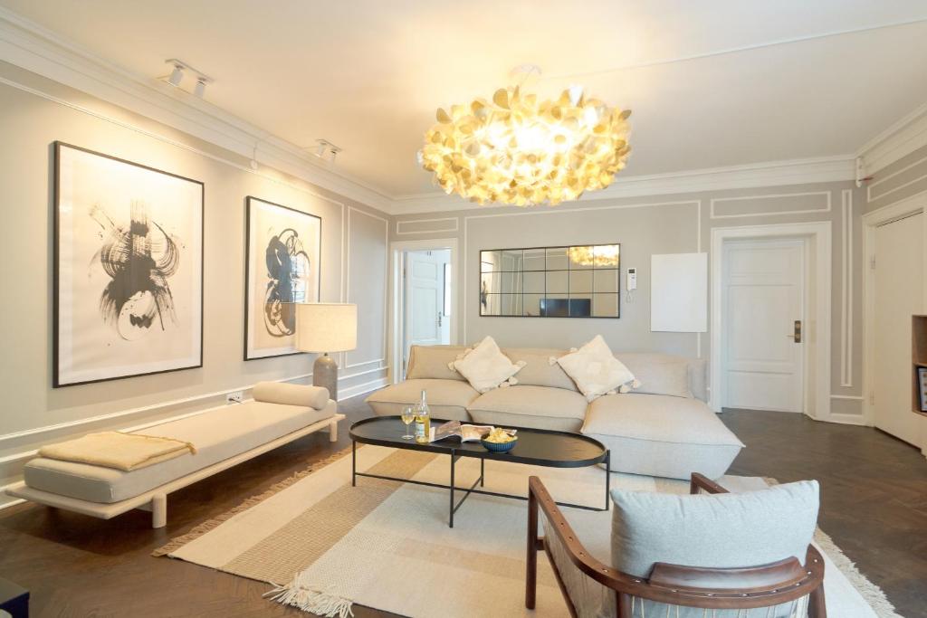 a living room with a couch and a chandelier at Stylish Spacious Flat w 3BR in Copenhagen City in Copenhagen