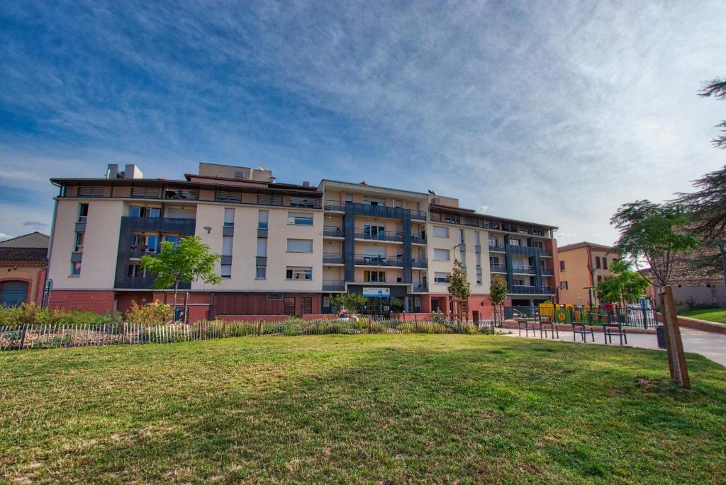 a large apartment building with a park in front of it at Zenao Albi - Résidence Stella in Albi