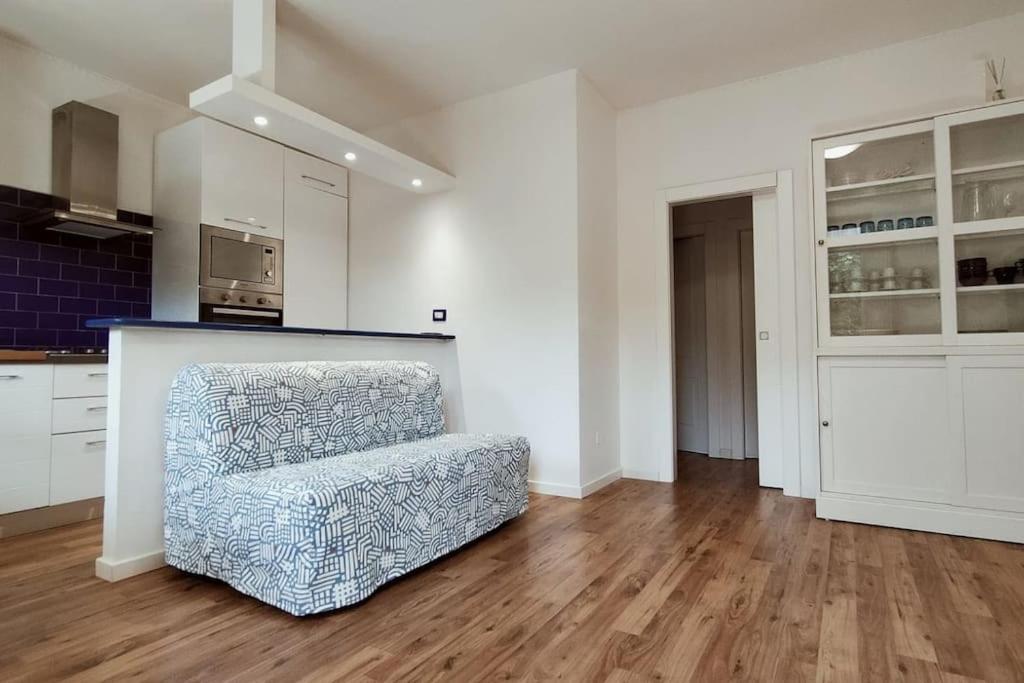 a living room with a chair and a kitchen at MareBlu Appartamento in Marina di Castagneto Carducci