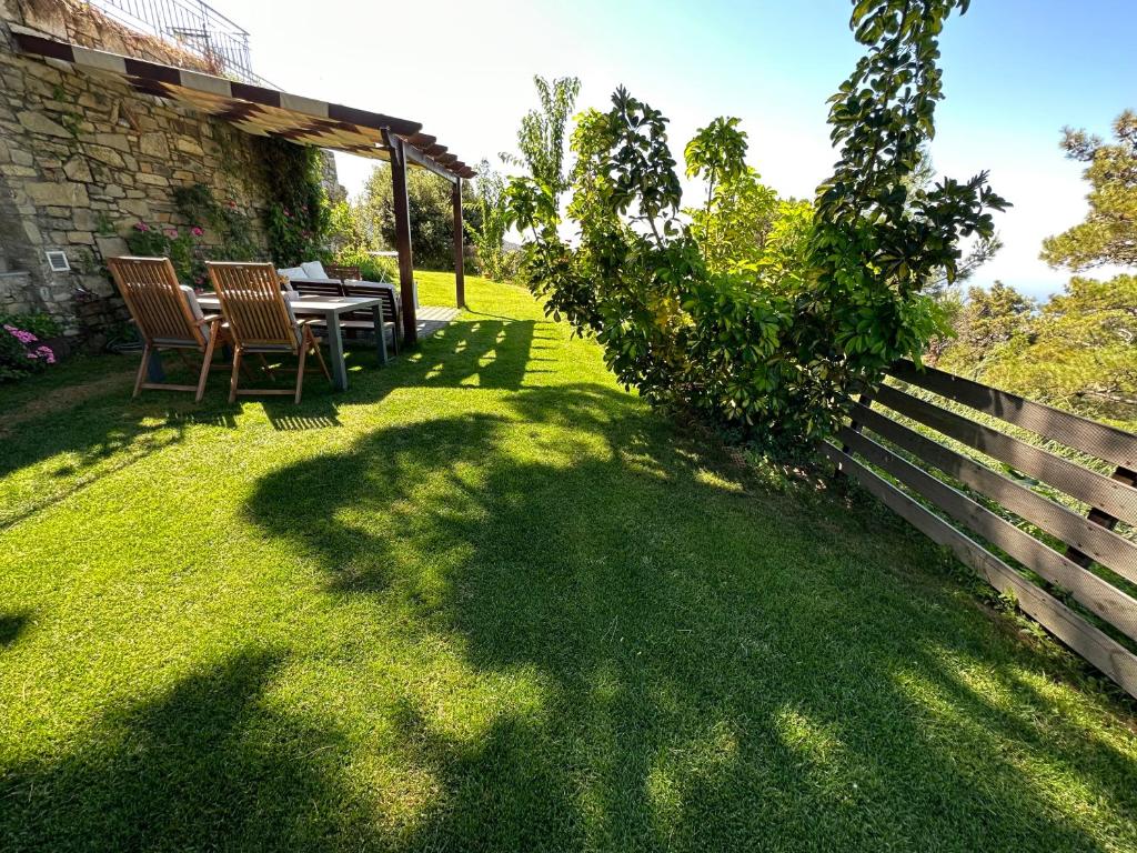a garden with a table and chairs and a fence at Chálari in Raches