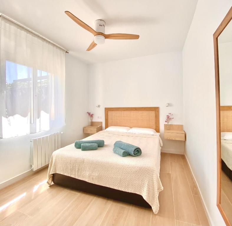 a bedroom with a bed with a ceiling fan at Sa Conca in S'agaro
