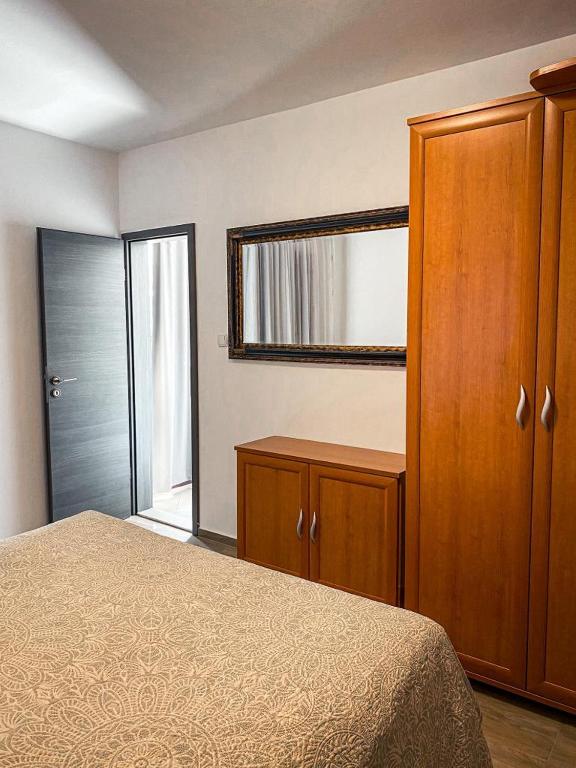 a bedroom with a bed and a closet and a mirror at SOBE/ROOMS RIVA in Zadar