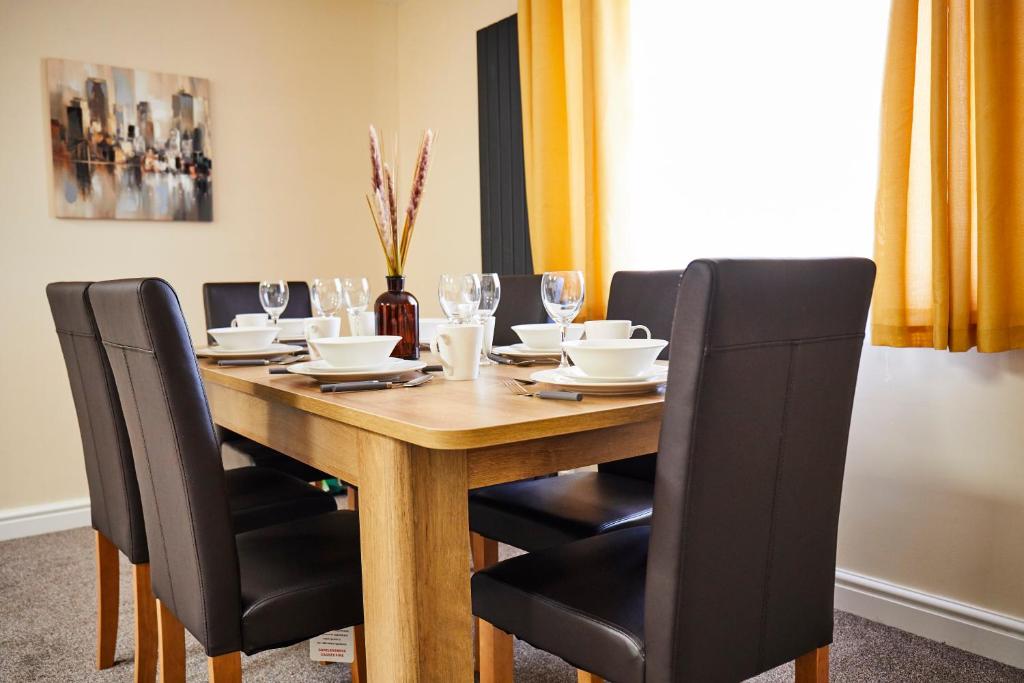 uma mesa de jantar com cadeiras pretas e uma mesa de madeira em White Jasmine In Stroud em Stroud
