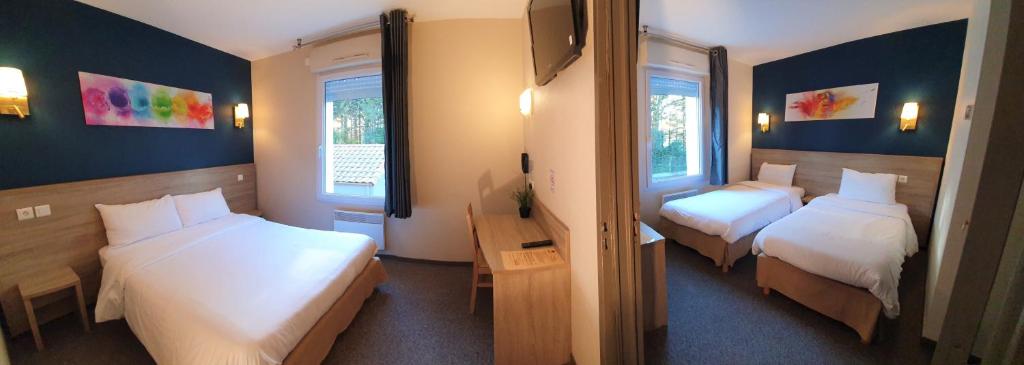 a hotel room with two beds and two windows at Hotel Salea in Pornic