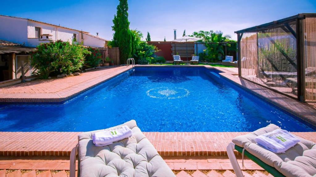 a swimming pool with two lounge chairs next to it at The Casita Spain Huercal-Overa by Ruralidays in Los Camachos